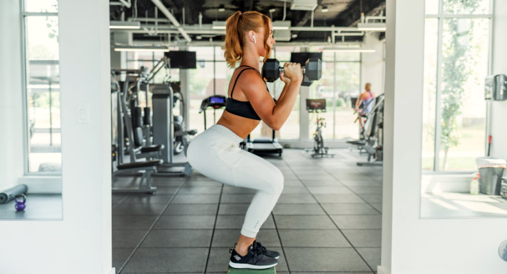 position squats sur-élevée en tenant des haltères